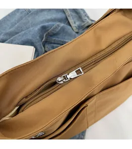 Detailed close-up of smooth metal zipper and brown canvas texture on tote bag