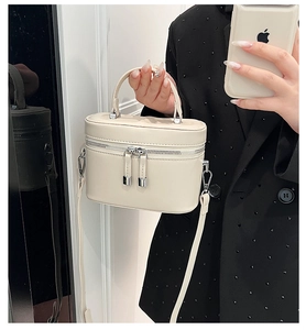 Détail du sac bandoulière crème en cuir lisse avec des finitions en métal argenté