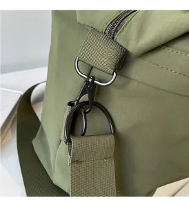 Close-up of durable gunmetal alloy swivel hook and D-ring on green nylon fabric