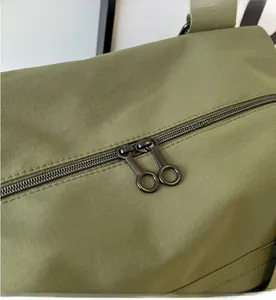Detail of olive green nylon bag featuring durable round metal dual zippers for smooth use