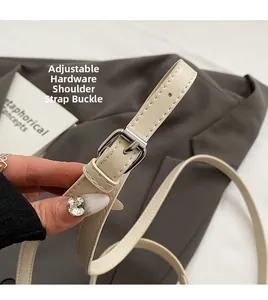 Détail de la bandoulière réglable en cuir crème avec boucle argentée et surpiqûres