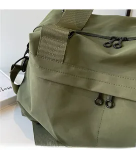 Detail of olive green nylon tote bag featuring durable fabric and metal zipper closure