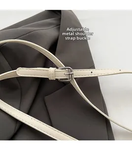 Close-up of adjustable faux leather shoulder strap with silver metal pin buckle detail