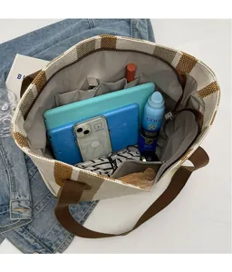 Interior view of large capacity plaid tote bag showing multiple pockets and spacious storage