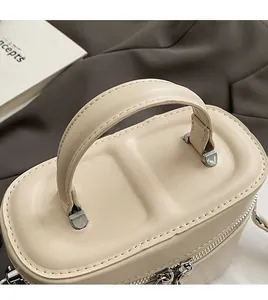 Gros plan du sac seau beige montrant la poignée confortable et le détail du zip fluide