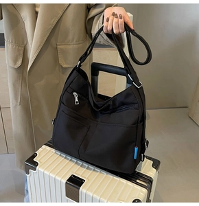 Close-up of a black high-capacity nylon tote bag featuring multiple functional pockets