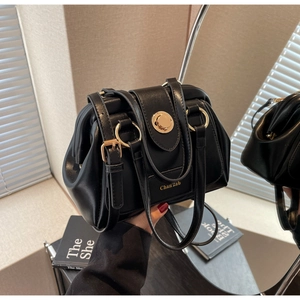 Detail view of black Boston bag with gold metal hardware and Chan'zab logo text