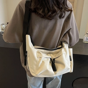 Versatile off-white canvas tote bag with large double pockets and wide black strap