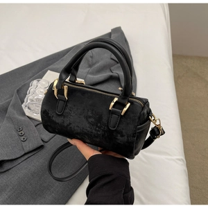 Detail of black Boston bag showing gold hardware and textured faux leather finish