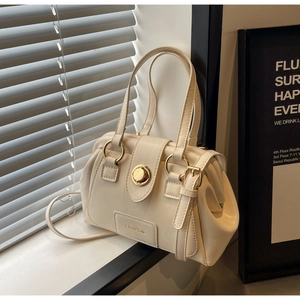 Detail of off-white Boston bag featuring gold metal ring handles and side pleats