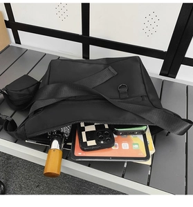 Detail view of large black nylon tote bag showing spacious compartments and storage capacity