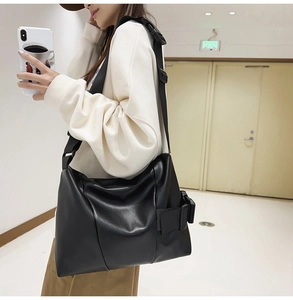 Detail of matte black tote bag with adjustable wide shoulder strap and plastic buckle