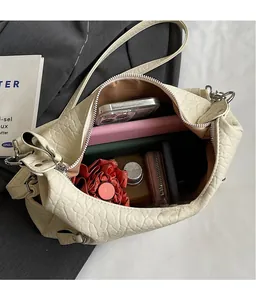 Vue intérieure d'un grand sac cabas plissé blanc cassé contenant téléphone et parapluie