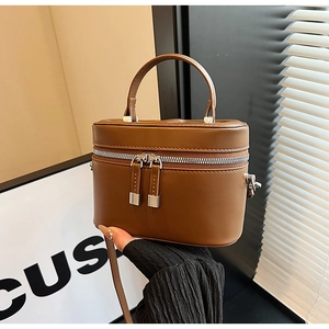 Détail du mini sac seau carré marron avec fermetures éclair argentées et poignée