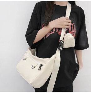 Detail of off-white canvas tote bag with wide strap and matching mini coin pouch