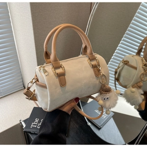Detail of Boston bag with cream matte finish, brown leather trim, and cute plush charm