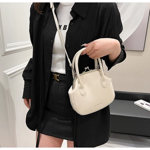 Detail of cream white retro doctor bag with top handle and crossbody strap on model