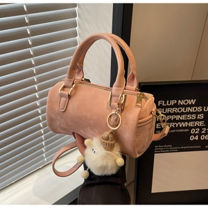 Detail of pink Boston bag showing leather texture, gold zippers, and plush lamb charm