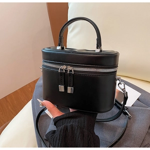 Détail d'un sac à main noir carré élégant avec finitions argentées et poignée ronde