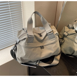 Detailed close-up of a large grey nylon tote bag with reinforced handles and durable zippers