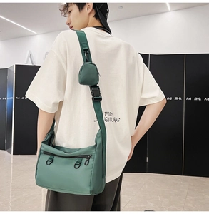 Detail of dark green waterproof nylon crossbody bag featuring a shoulder strap coin purse