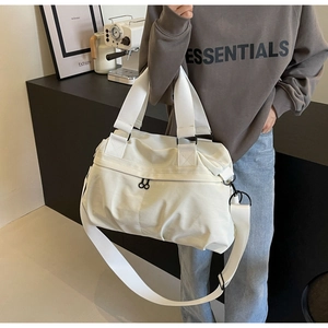 Close-up of white nylon tote bag showing durable handles and adjustable shoulder strap