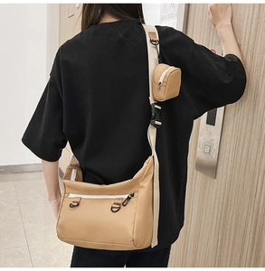 Close-up of khaki canvas tote with adjustable strap and matching mini pouch bag