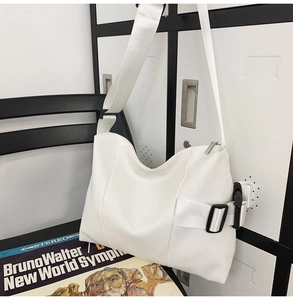 Detail view of white functional tote bag showing black side buckle and wide strap