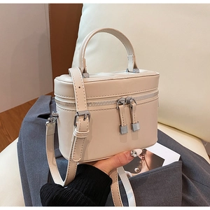 Détail du mini sac seau en cuir beige avec fermeture éclair argentée et poignée
