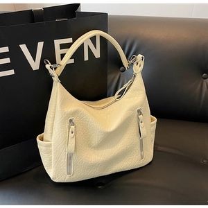 Détail du sac fourre-tout en cuir plissé crème avec fermetures éclair argentées
