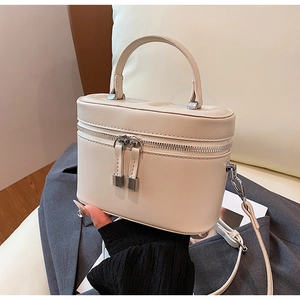 Détail d'un mini sac boîte en cuir blanc avec finitions argentées et poignée