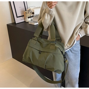 Detail of olive green nylon tote bag featuring wide handles and adjustable strap
