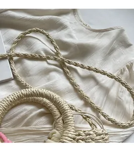 Detail of hand-woven straw bag with long shoulder strap and smooth natural fiber texture