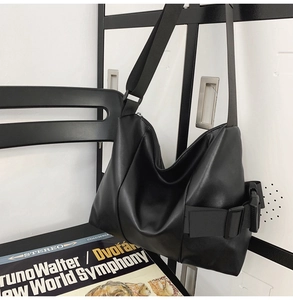 Detail of black PU leather hobo bag featuring wide strap and soft matte texture