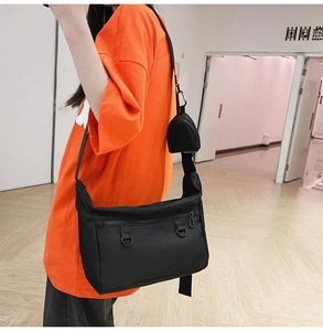 Practical black canvas messenger bag featuring front zipper pocket and detachable mini pouch
