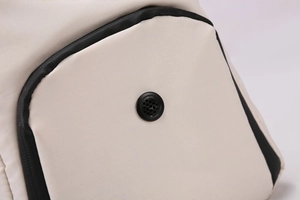 Close-up of beige waterproof oxford fabric with black piping and built-in headphone port