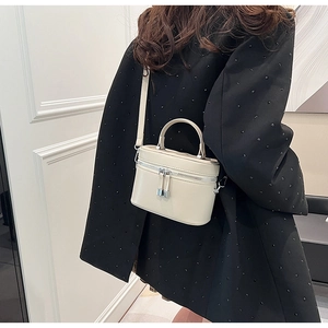 Vue détaillée du mini sac seau crème avec quincaillerie argentée et fermeture à glissière