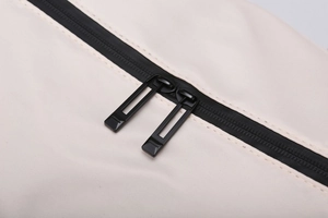 Macro shot of durable double black metal zippers on off-white waterproof oxford travel bag