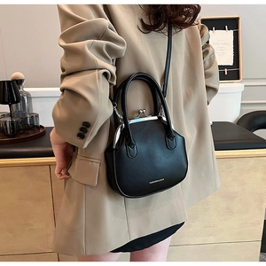 Detail of classic black doctor bag style crossbody with silver metal clasp closure