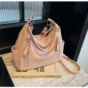 Détails du sac cabas rose texturé avec fermetures éclair et bandoulière longue