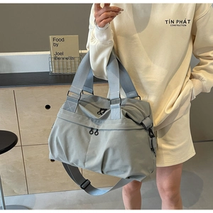 Detail of gray nylon tote bag with reinforced handles and adjustable shoulder strap