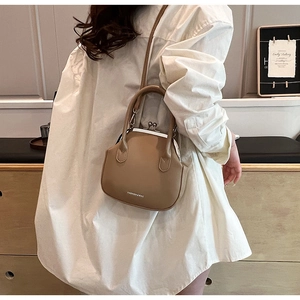 Detail of vintage khaki doctor bag with metal kiss-lock closure and dual handles
