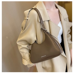 Detail of dark brown leather crescent hobo bag featuring polished finish and metal buckle