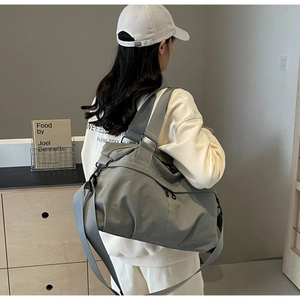 Detail of grey nylon tote bag showing side pocket and spacious shoulder carry design