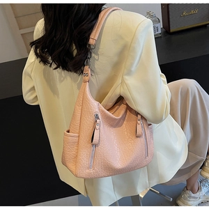 Détail du sac cabas rose avec fermetures éclair verticales et poche latérale sur modèle
