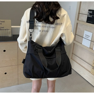 Detail of black nylon tote bag showing spacious interior and adjustable shoulder strap