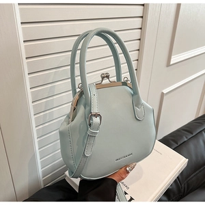 Detail of light blue doctor bag with vintage metal clasp and leather strap decoration