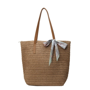 Large woven straw tote bag with brown leather handles and a decorative floral scarf