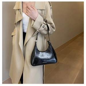 Detail of black glossy hobo bag with crinkle texture and Fashion & Bag lettering