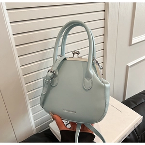 Detail of light blue mint green crossbody bag with vintage metal clasp and top handle